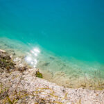 Beautiful mountain landscape – a lake with unusual turquoise water in the crater. Chalk quarry in Belarus.